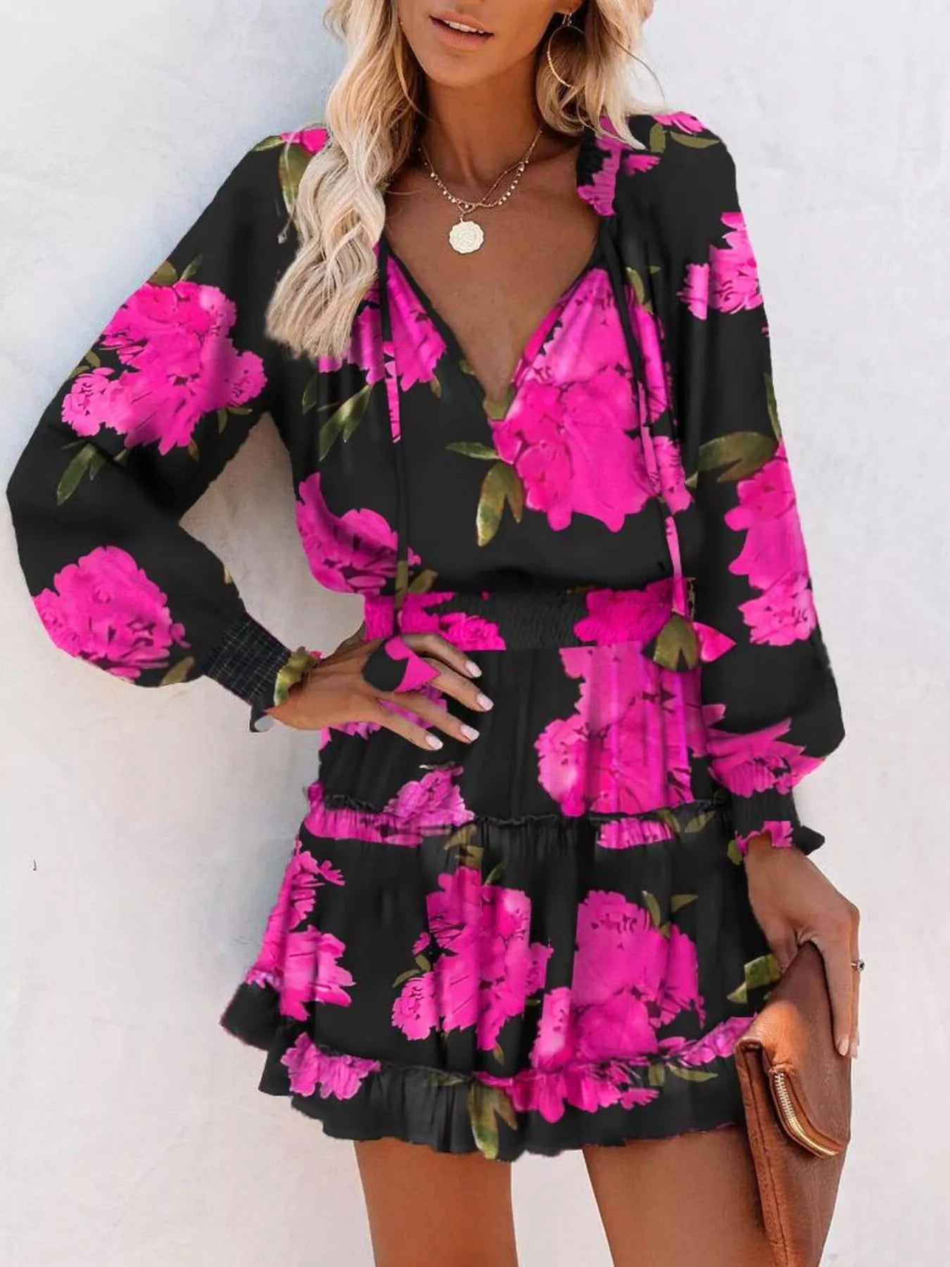 Tie-neck lantern sleeve dress in black with bright pink floral print and ruffled tiered hem.