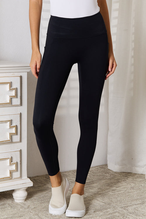 Black sports leggings with wide waistband and ankle-length fit