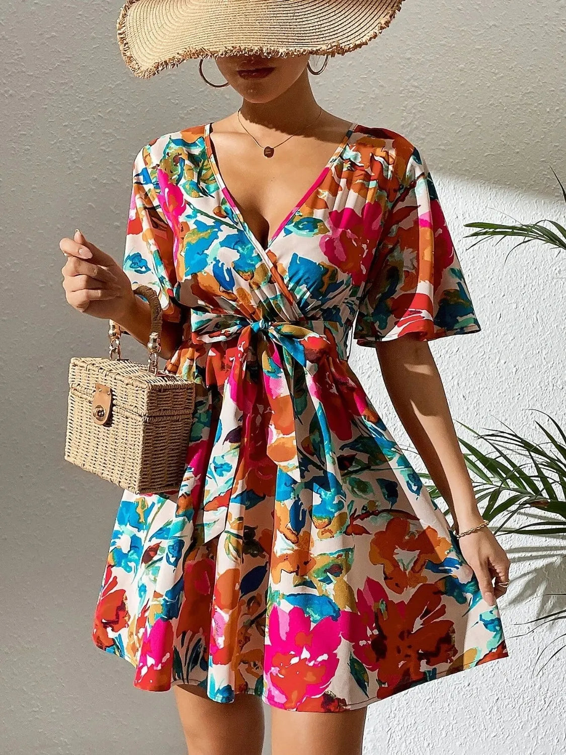 Printed surplice short sleeve mini dress with colorful floral print and waist tie