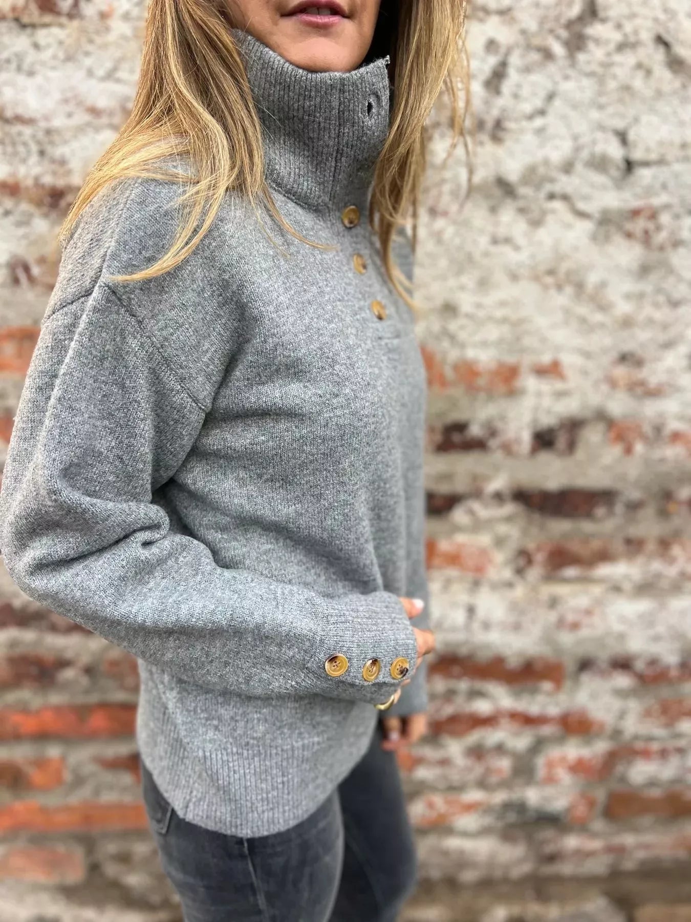 Grey knit turtleneck sweater with button placket and long sleeves, gold-tone cuff buttons