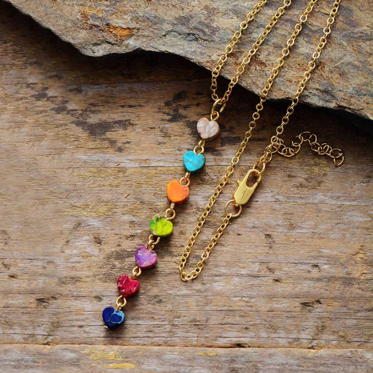 Gold-tone heart charm necklace with mixed-color heart stones and a small clasp
