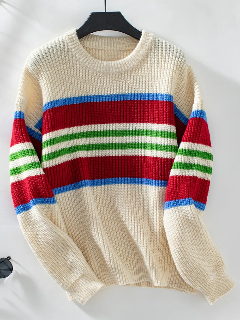 Cream round-neck striped sweater on a hanger with long sleeves