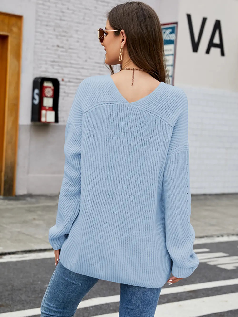 Light blue long sleeve sweater, back view, dropped shoulders with ribbed cuffs and knit texture