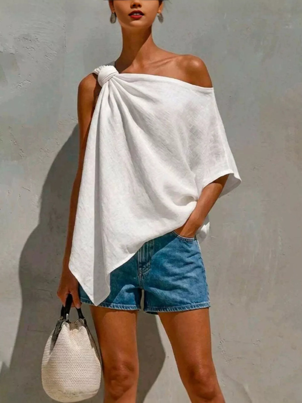 White one-shoulder blouse with knotted neckline and draped asymmetrical hem
