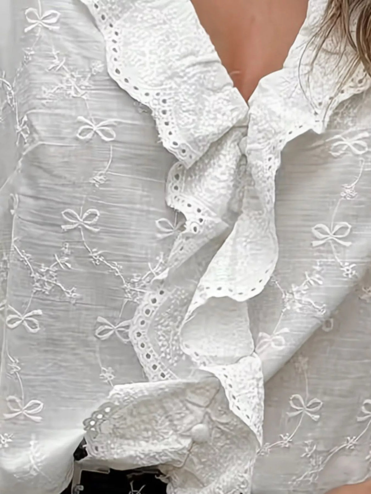 White embroidered blouse with eyelet ruffle V-neck and bow pattern trim