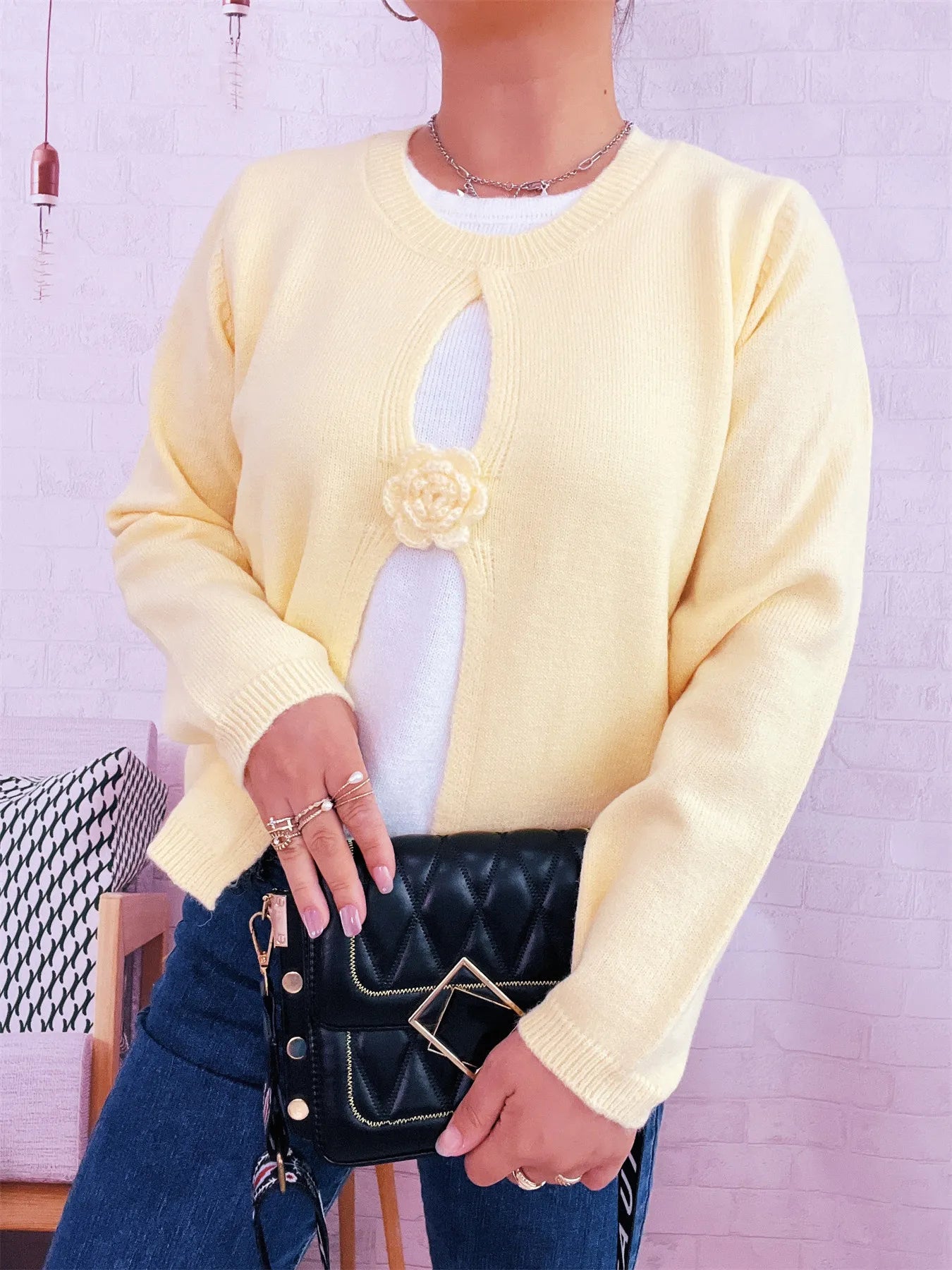 Cream round-neck sweater with white contrast front panel and flower appliqué at chest