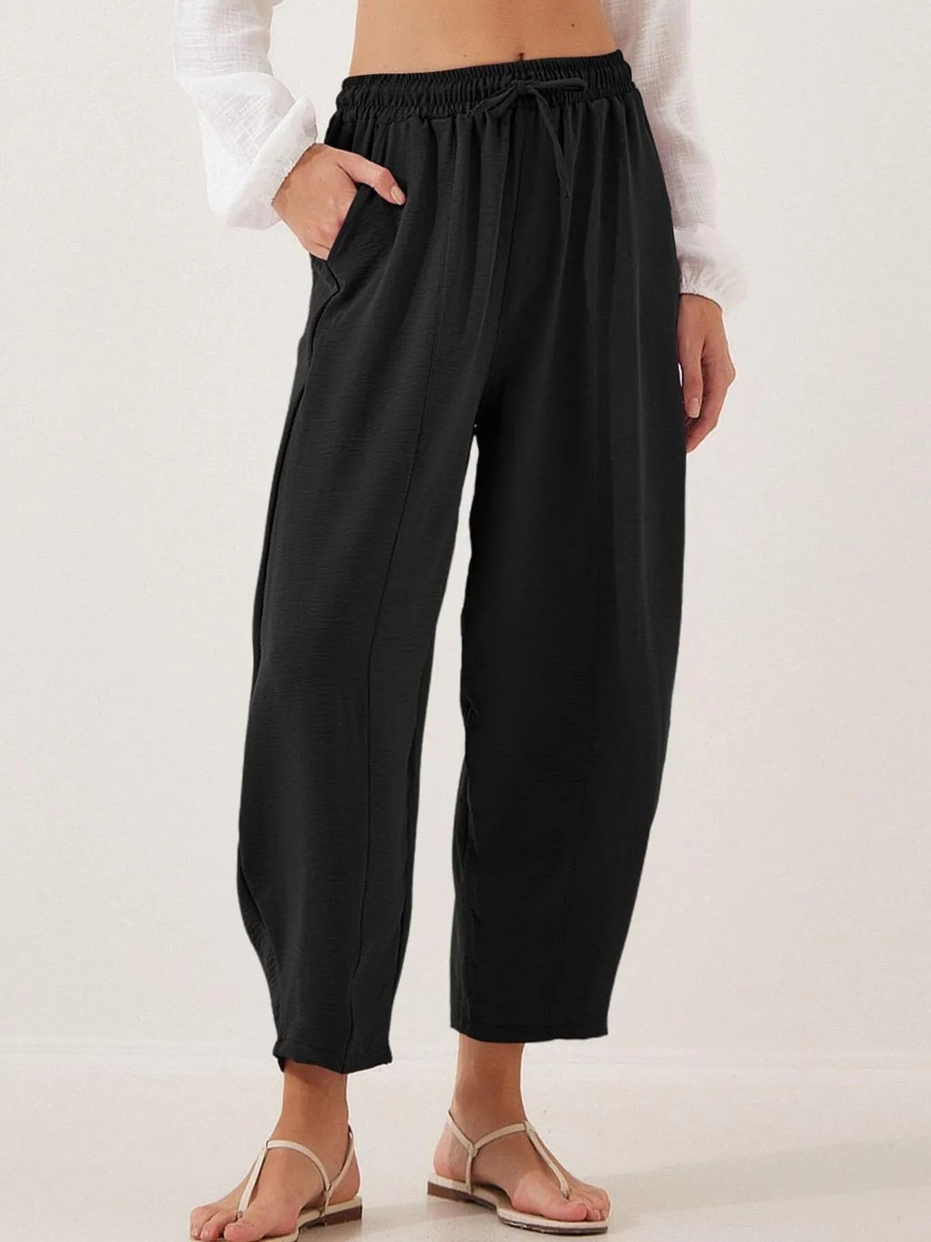 Black cropped wide-leg pants with drawstring elastic waist, loose drape