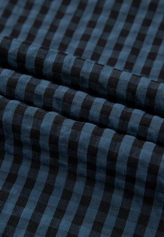 Dark blue plaid fabric panel for overalls with stitched seams