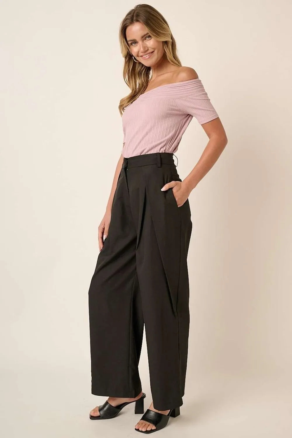Black high-waisted wide-leg pants with deep front pleats and draped legs