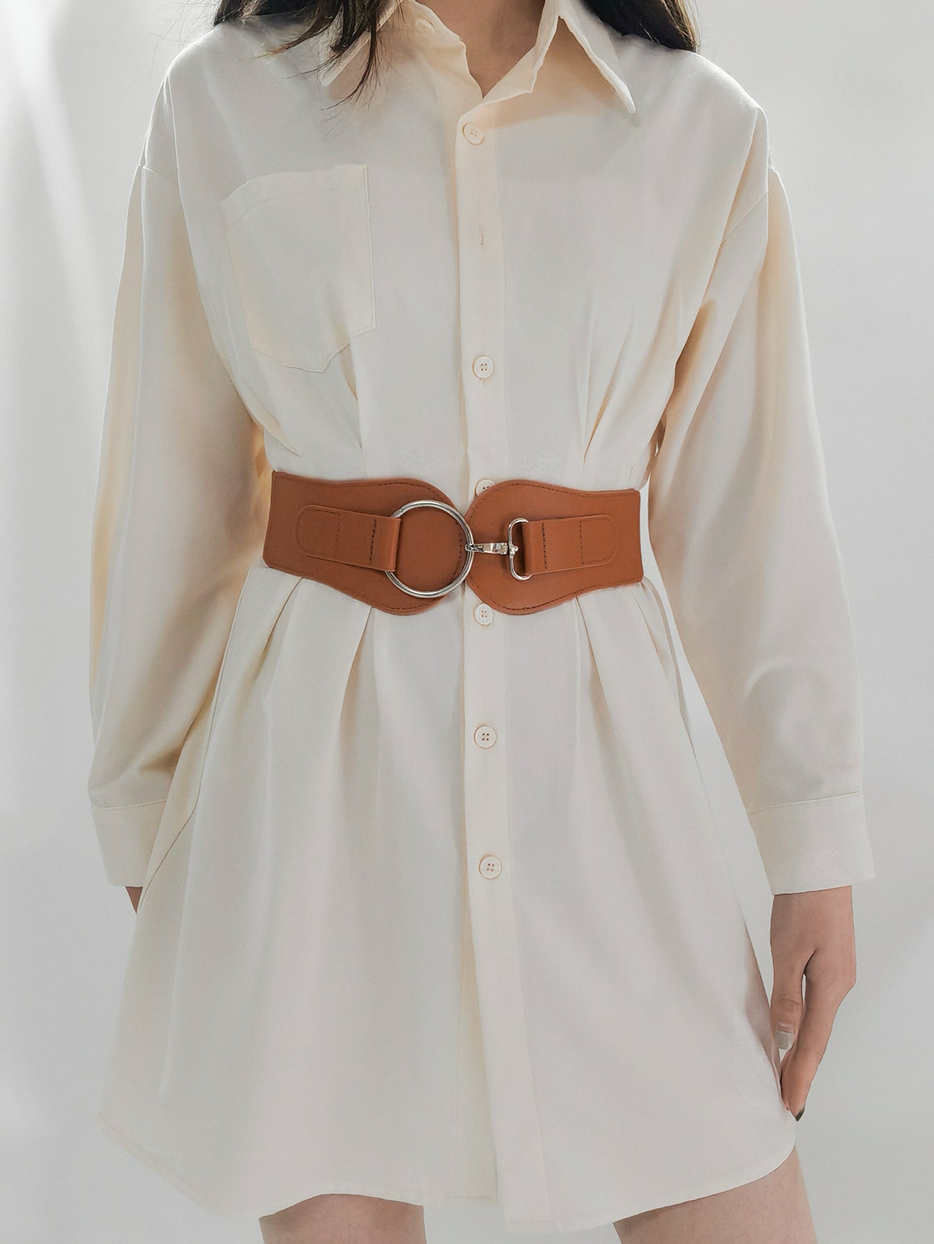 Caramel vegan leather wide elastic belt with O-ring buckle around a light dress