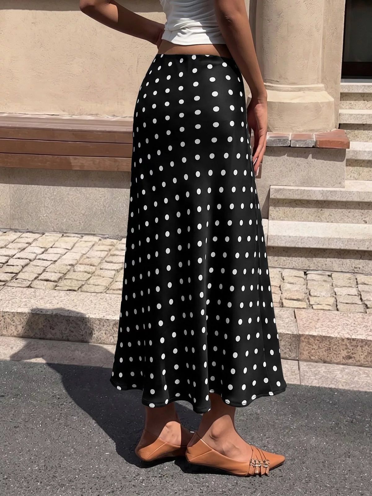 Black stretch midi skirt with white polka dots, full-length A-line drape