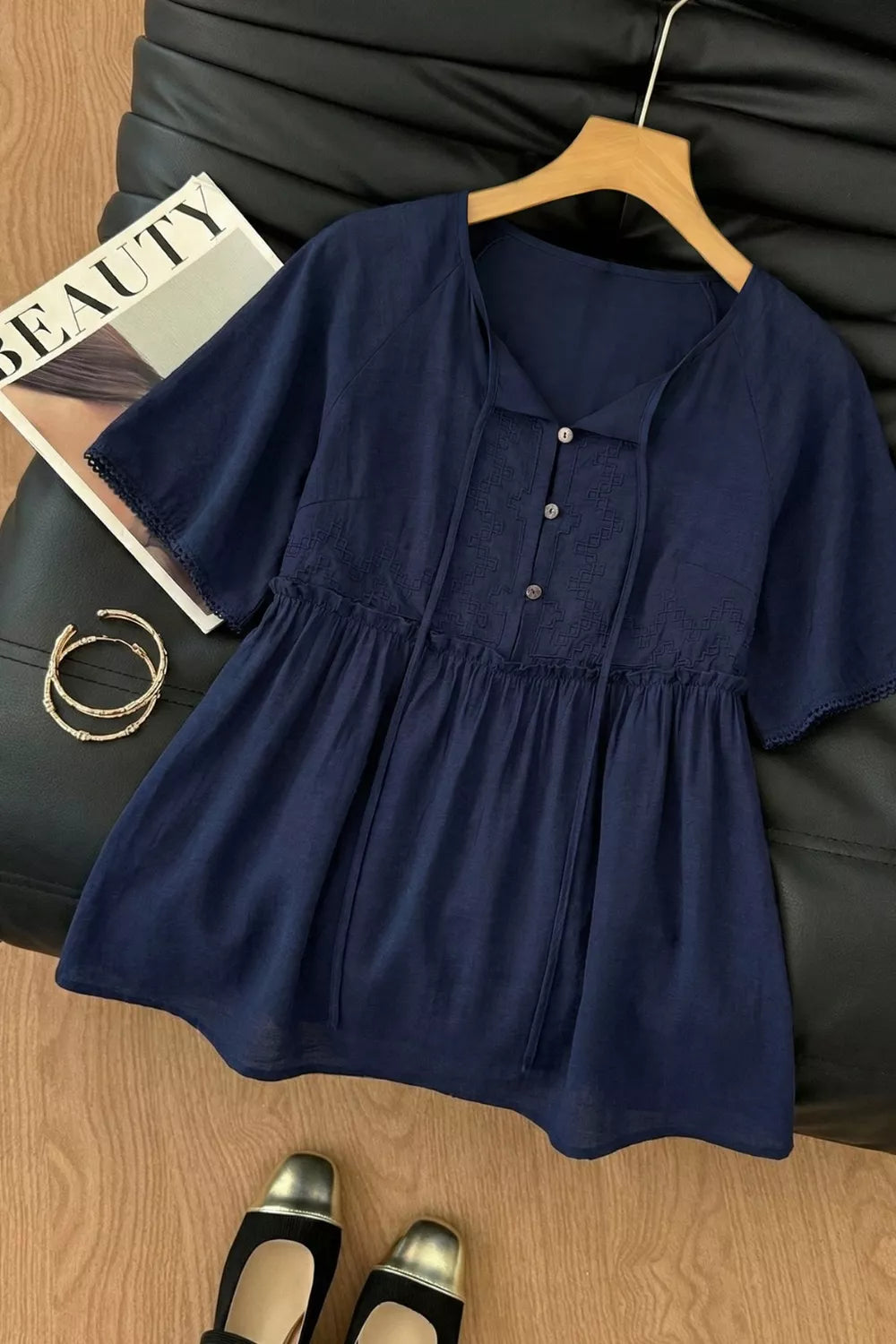 Ruffle-hem tie-neck blouse in navy blue with a buttoned front