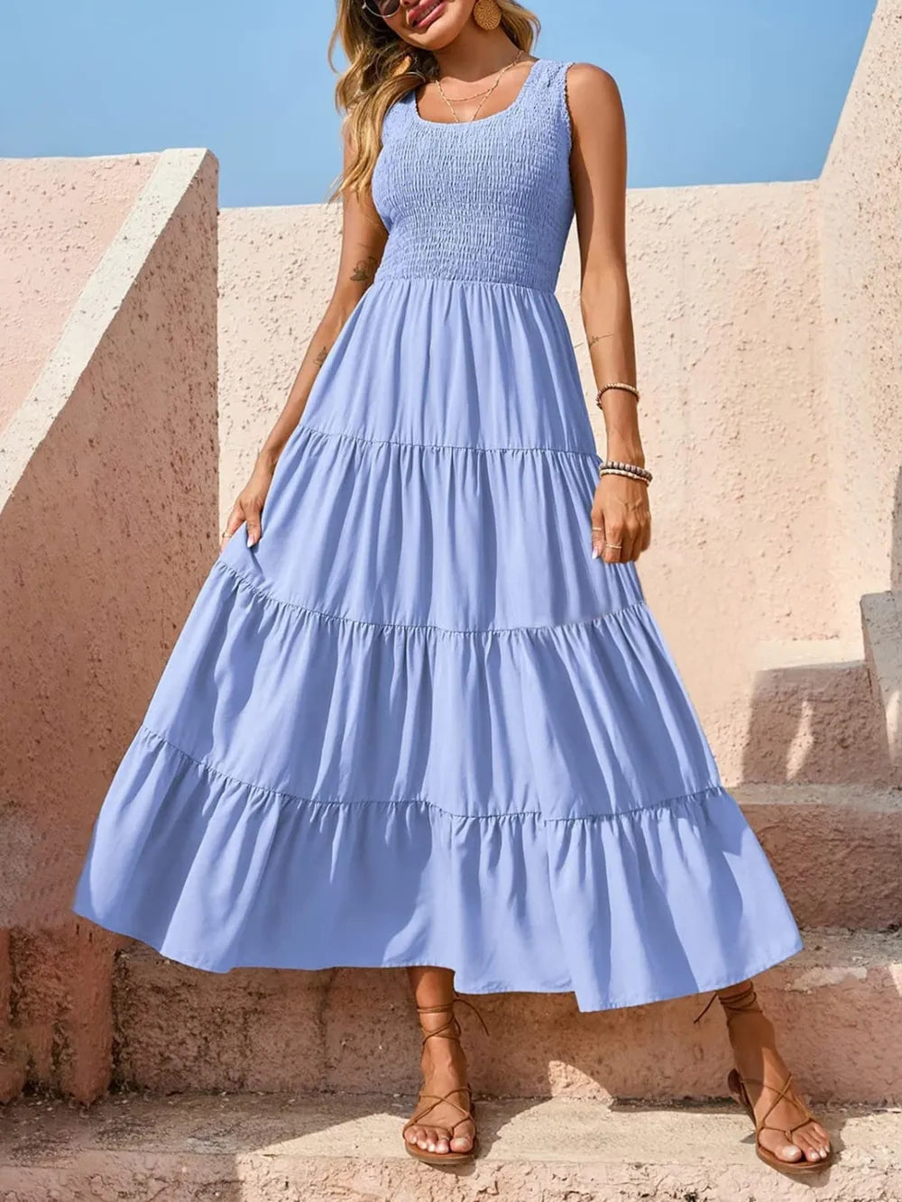 Tiered smocked wide strap dress in light blue with gathered tiered skirt.