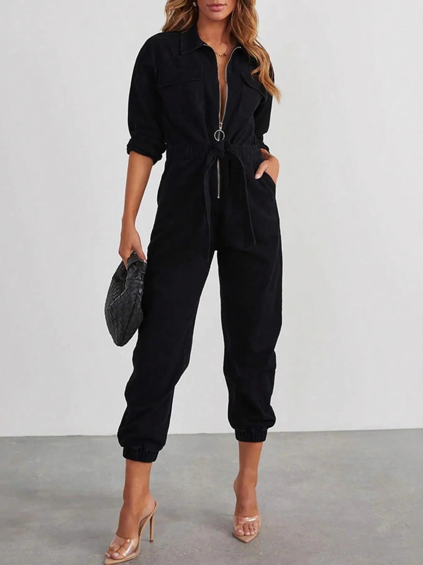 Black long-sleeve zip-front jumpsuit with drawstring waist and cuffed legs