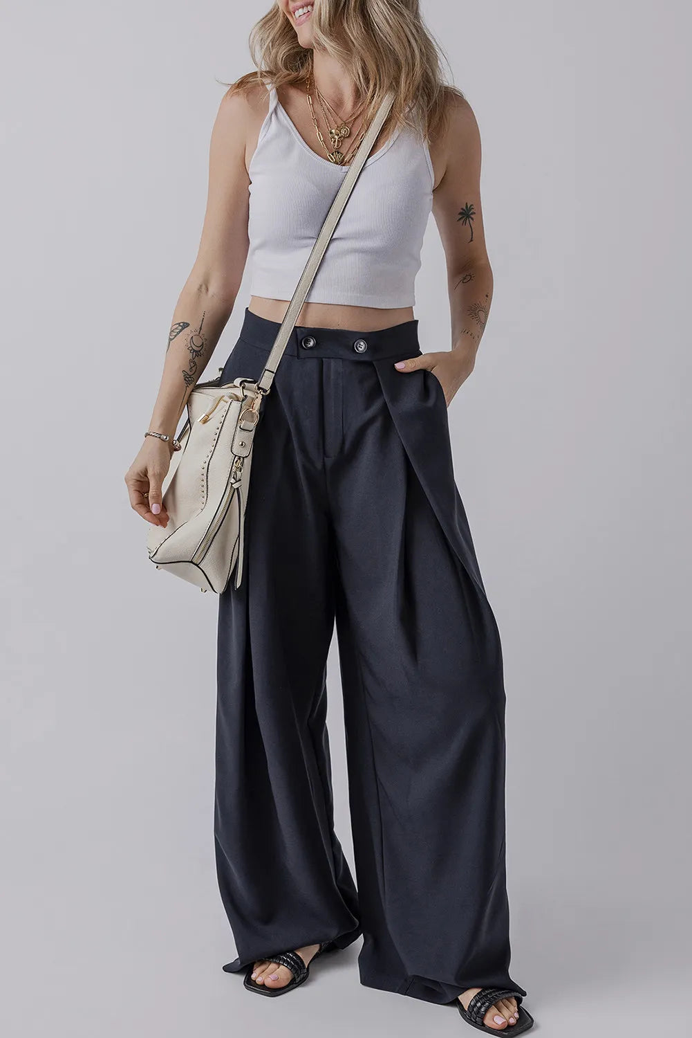 Dark navy high-waist wide-leg pants with pockets, pleated front and button closure.