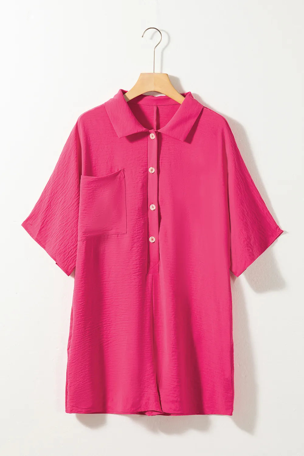 Hot pink half-button collared neck romper on hanger, front view
