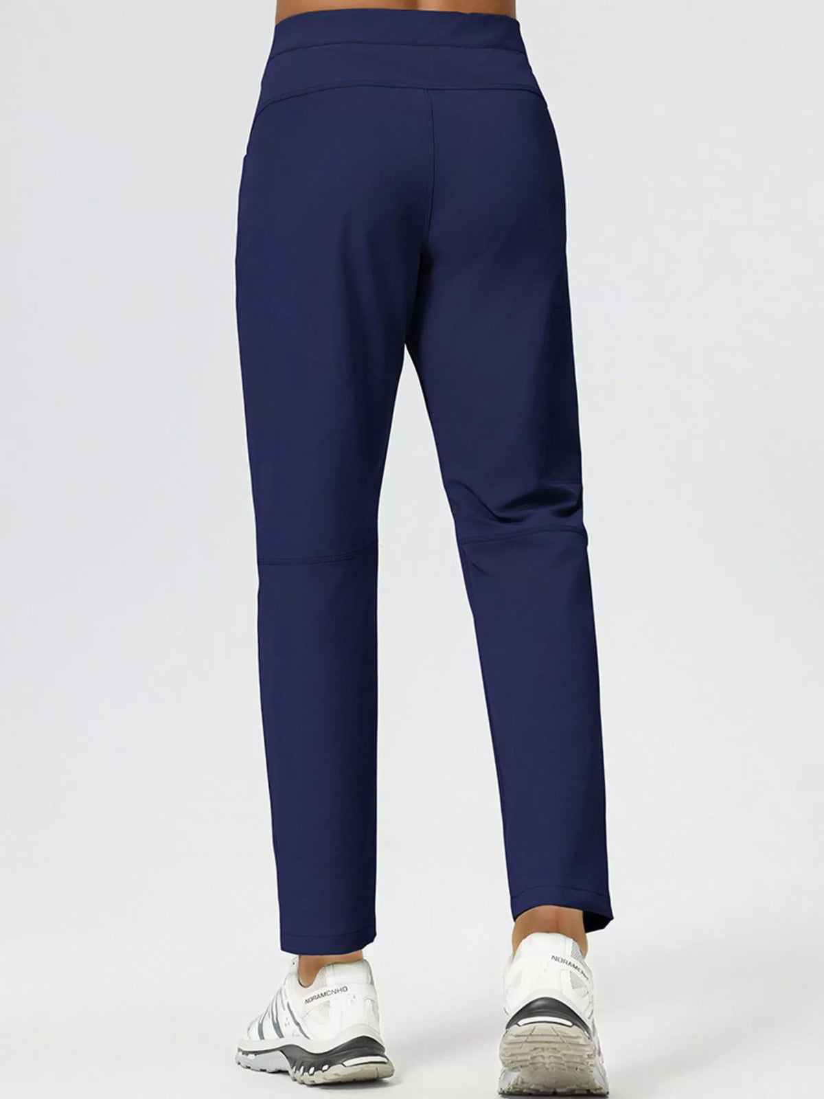 Men's slim-fit stretch casual pants in navy blue, back view with tapered legs