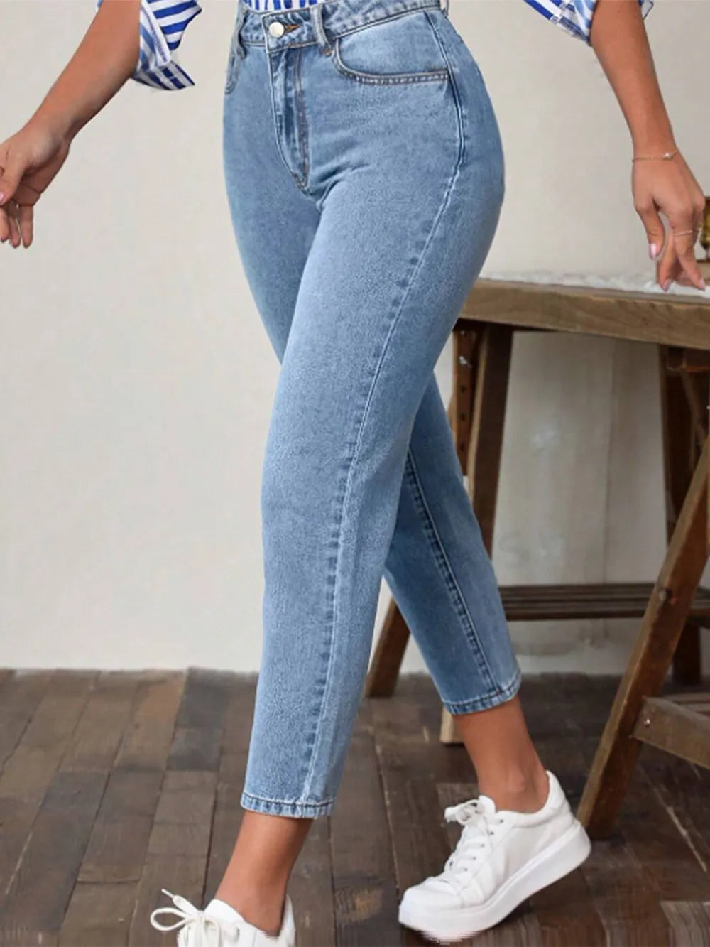 Light blue high-waist jeans with pockets, cropped ankle-length slim fit, side view