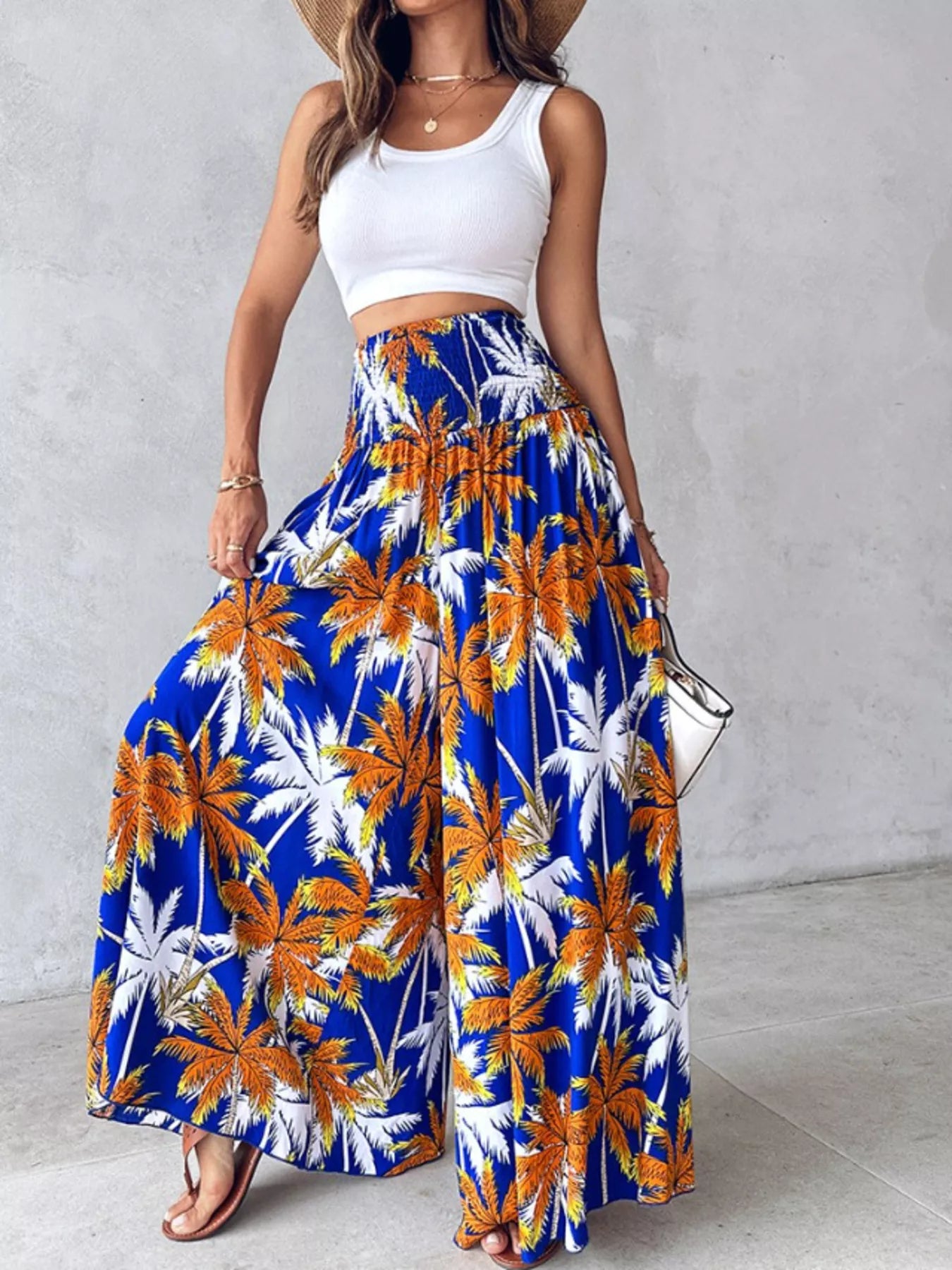 Printed wide-leg pants in blue with orange and white palm tree print, elastic waist.