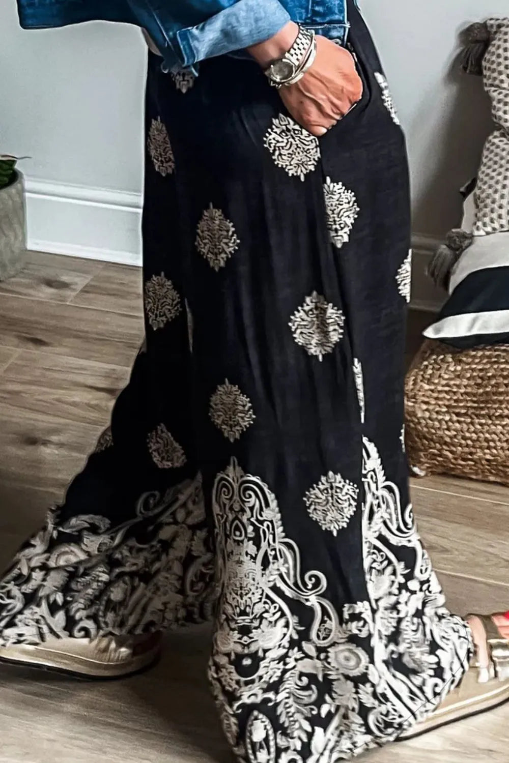 Black wide-leg pants with scattered white motifs and ornate hem panel