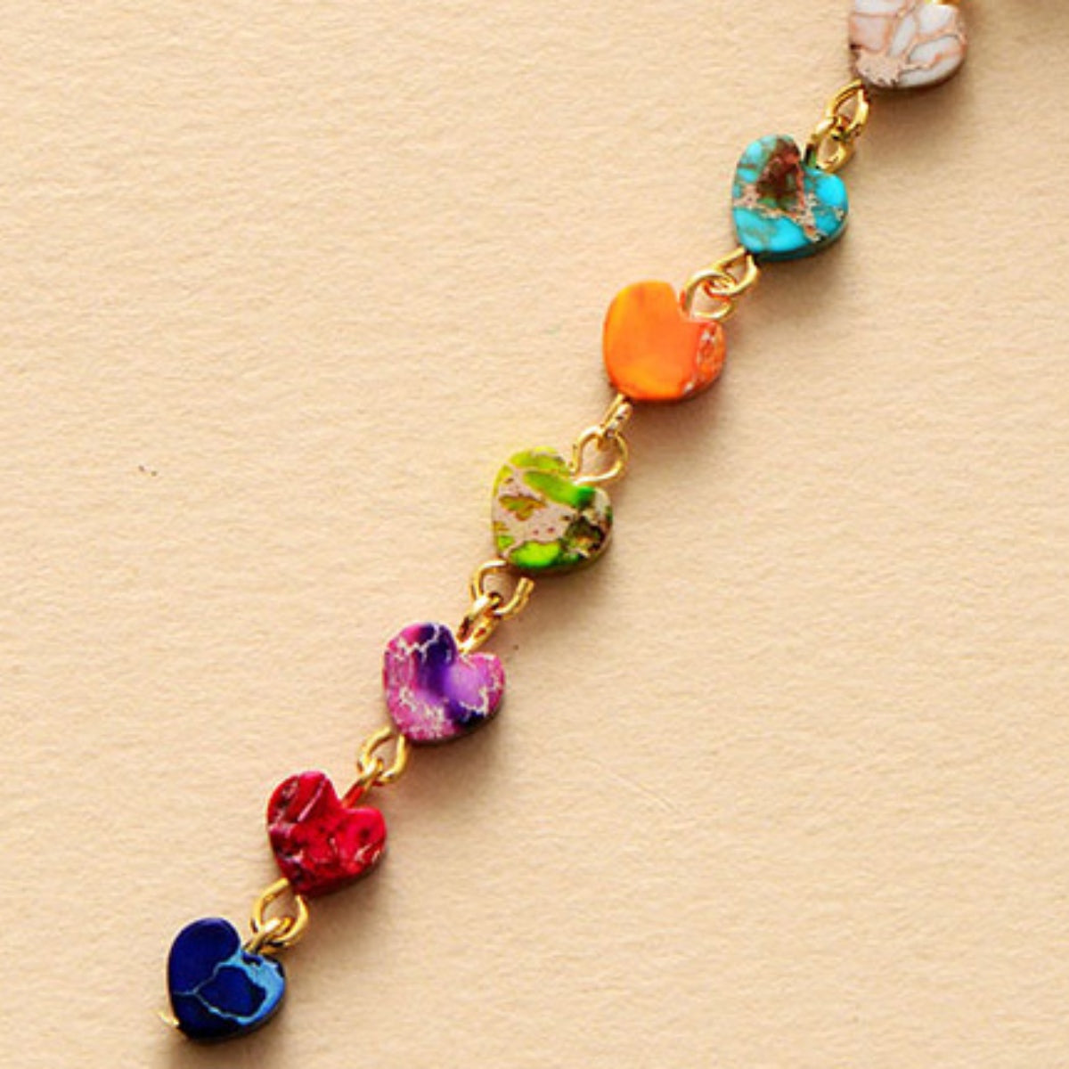 Gold-tone chain with multicolor heart-shaped stone beads and a white heart charm