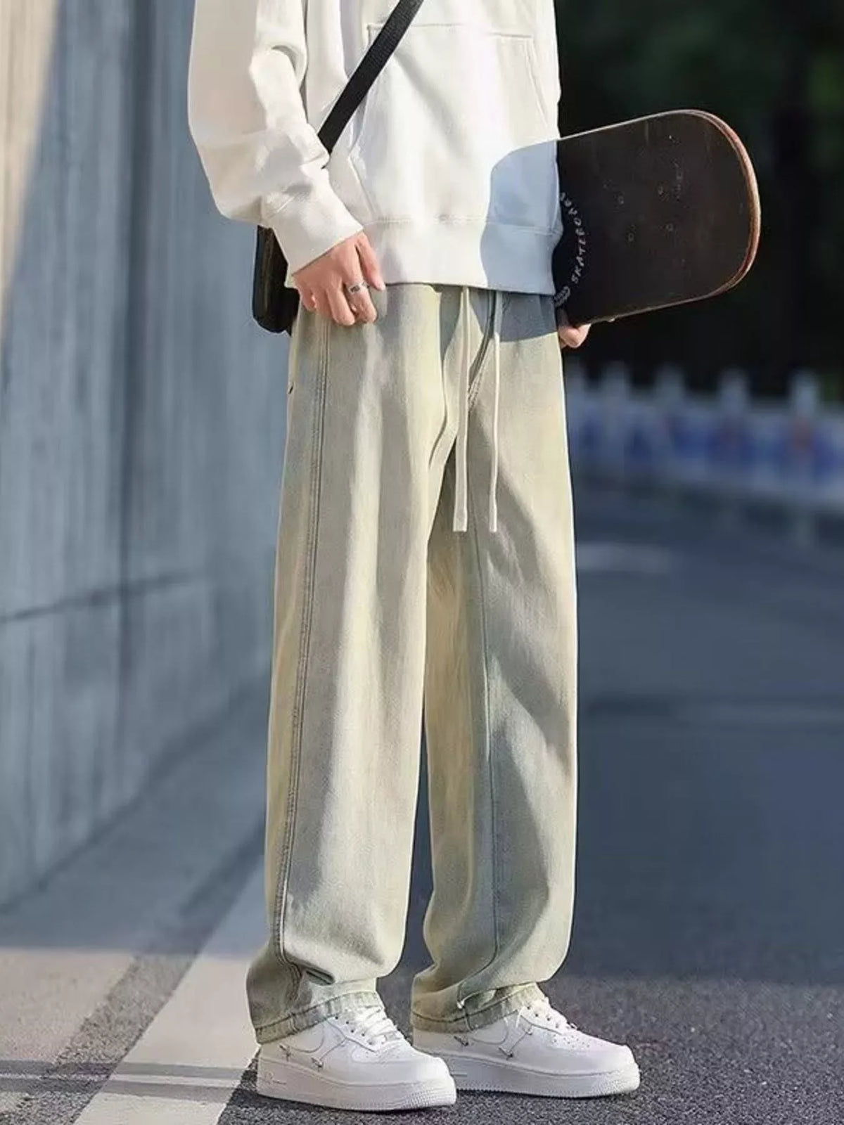 Tan washed denim jeans with loose fit, wide legs, and front drawstring ties