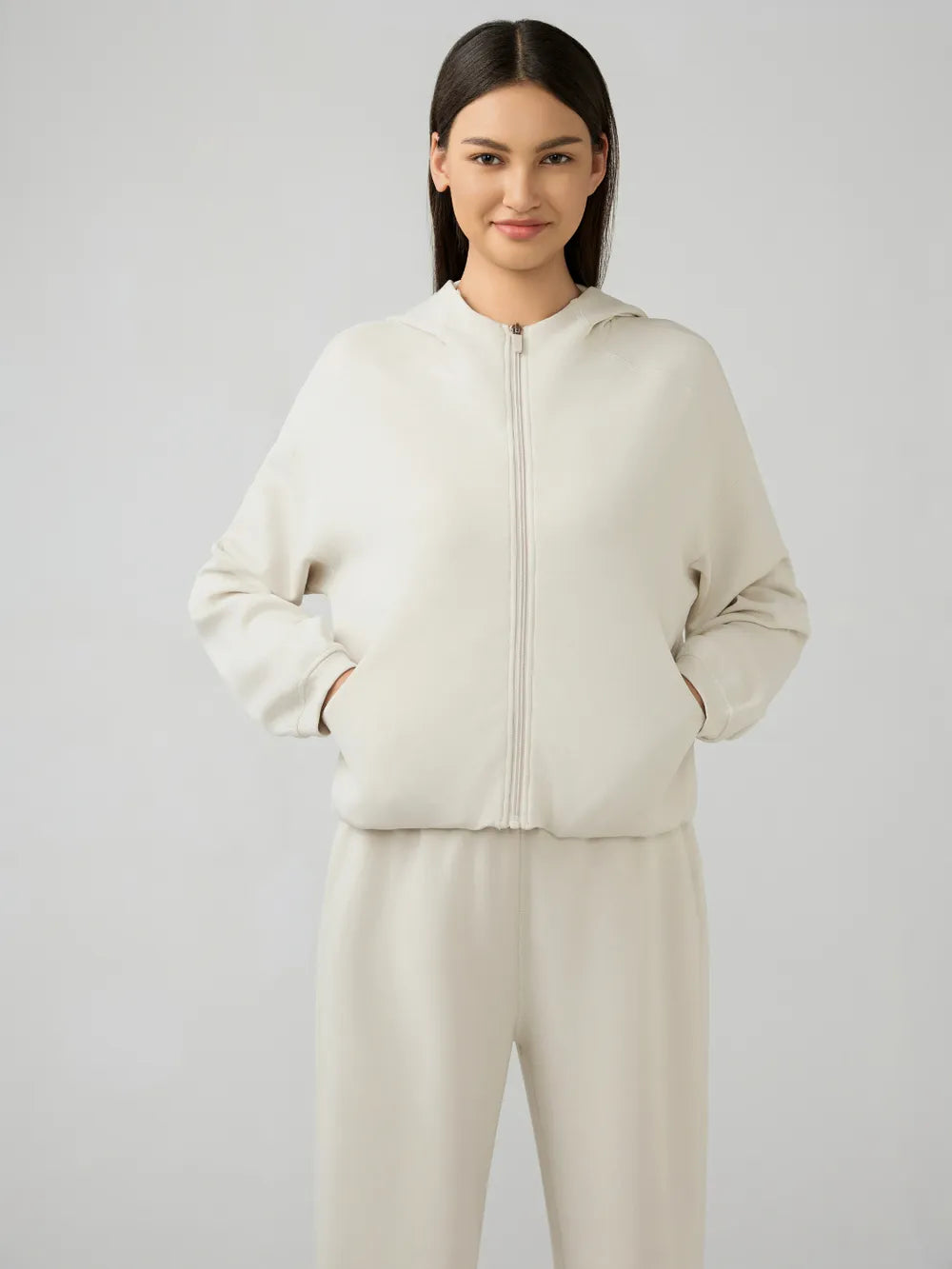 Cream zip-up hooded jacket with front zipper and dropped shoulders, long sleeves