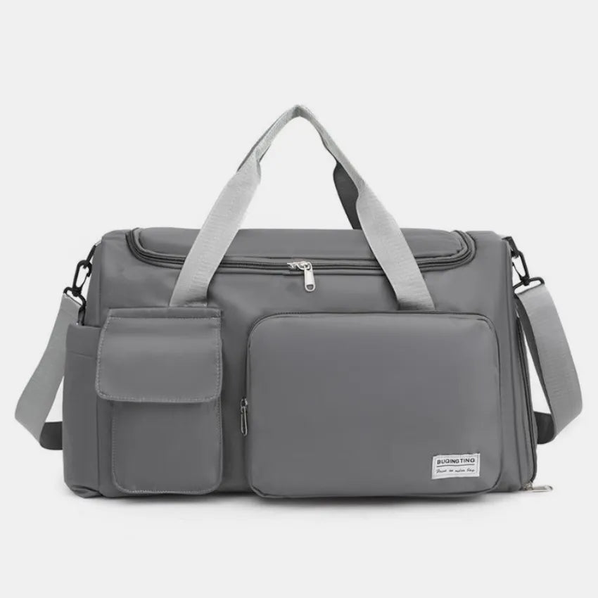 Large travel duffle bag with detachable straps, dark gray with front zip compartment.