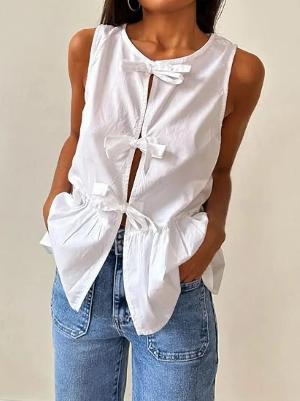 White sleeveless tank top with bow-tie placket and gathered peplum hem