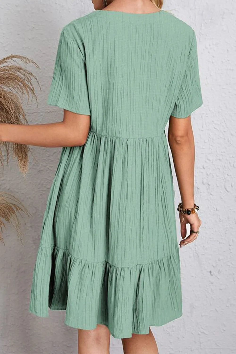 Green V-neck short-sleeve dress, back view, gathered waist and tiered hem