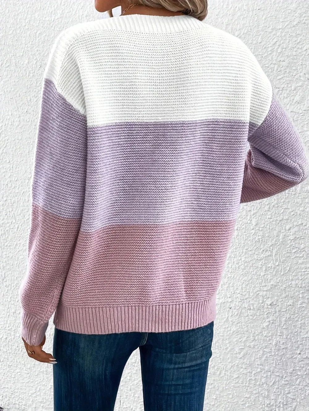 Back view of color block knit sweater in white and lilac/pink, boat neck, long sleeves.