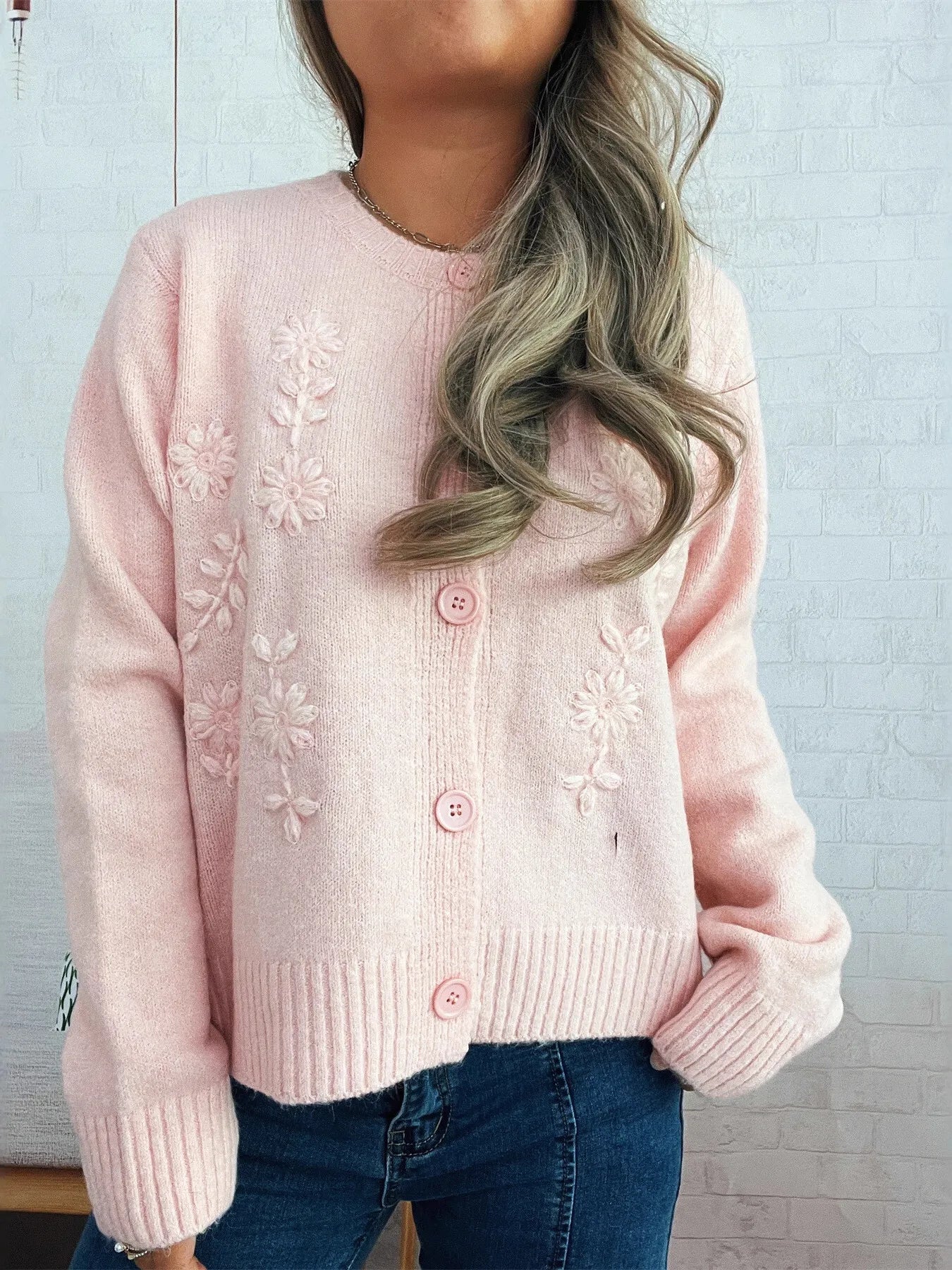 Pink ribbed-hem cardigan with flower embroidery and button front, long sleeves.