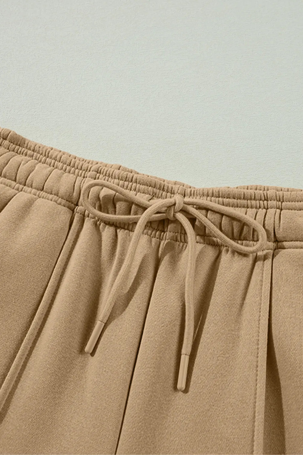 Tan drawstring waistband with elastic and braided cords, side pocket opening