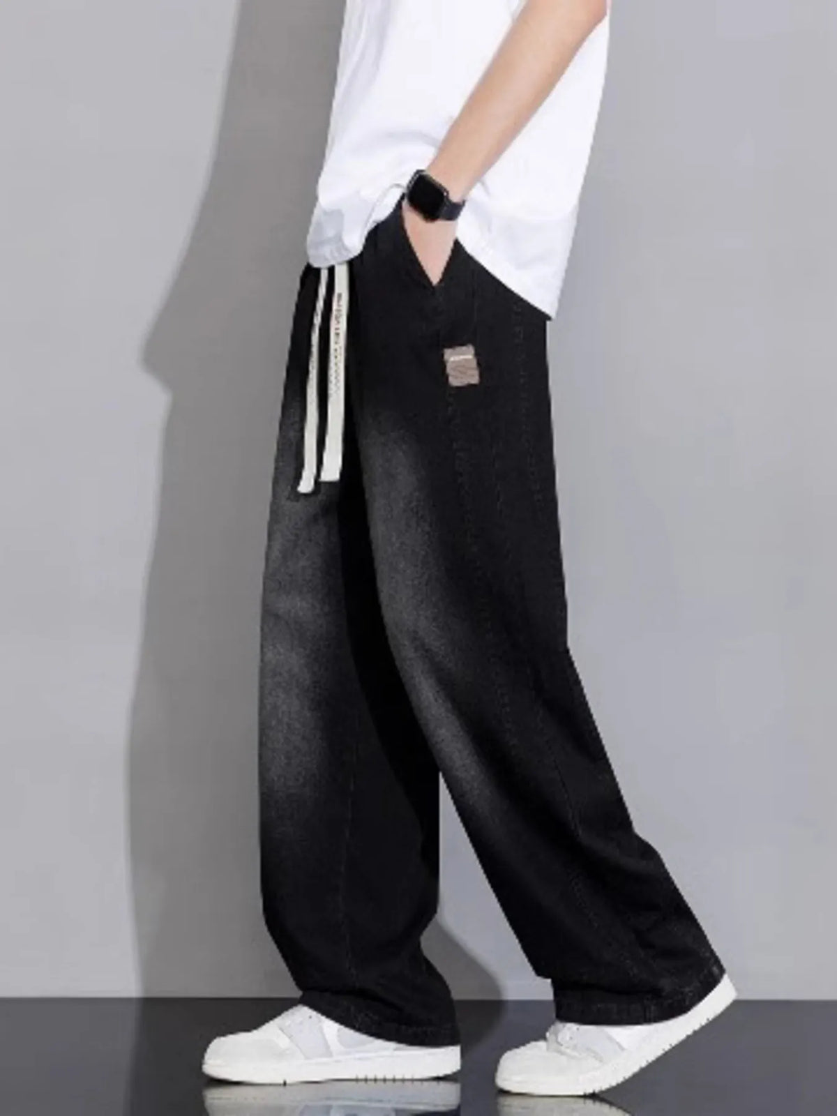 Men's black wide-leg drawstring jeans with vertical tie detail and relaxed fit