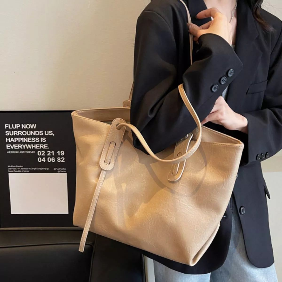 Khaki vegan leather shoulder tote bag with adjustable straps and front grommet details