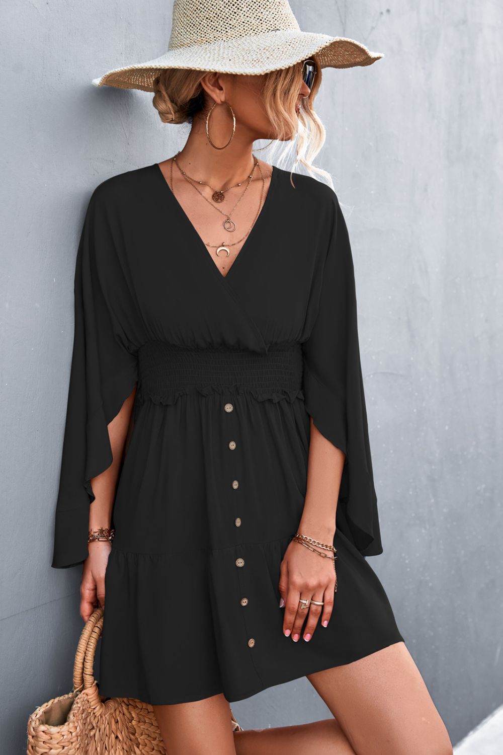 Black surplice dress with smocked waist, decorative buttons and flared sleeves