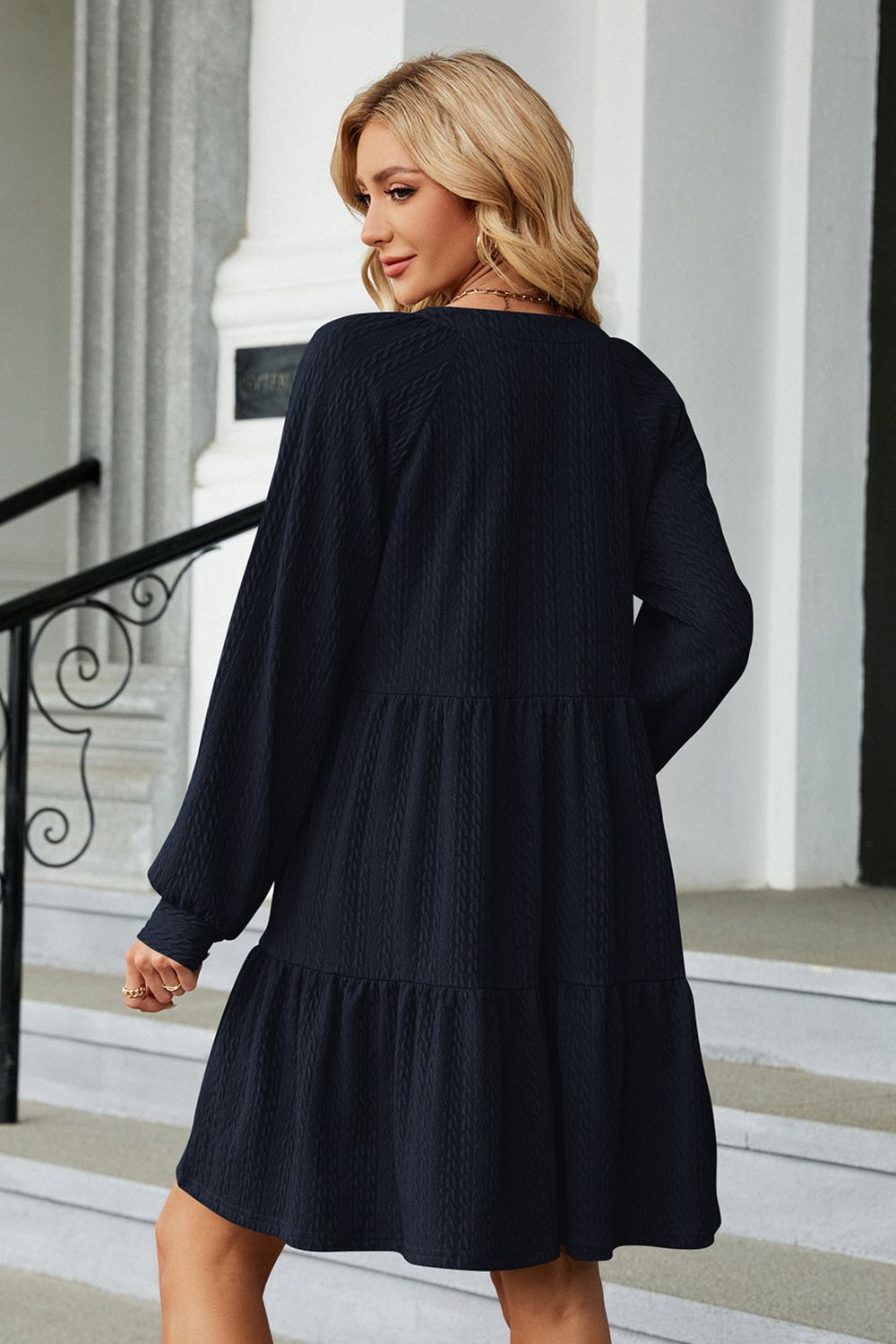 Dark blue notched neck long sleeve mini dress, back view with tiered skirt