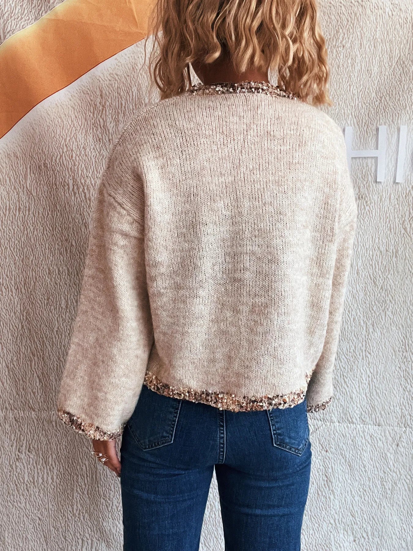 Light gray cropped round-neck sweater, back view, rose-gold sparkling trim at hem and cuffs