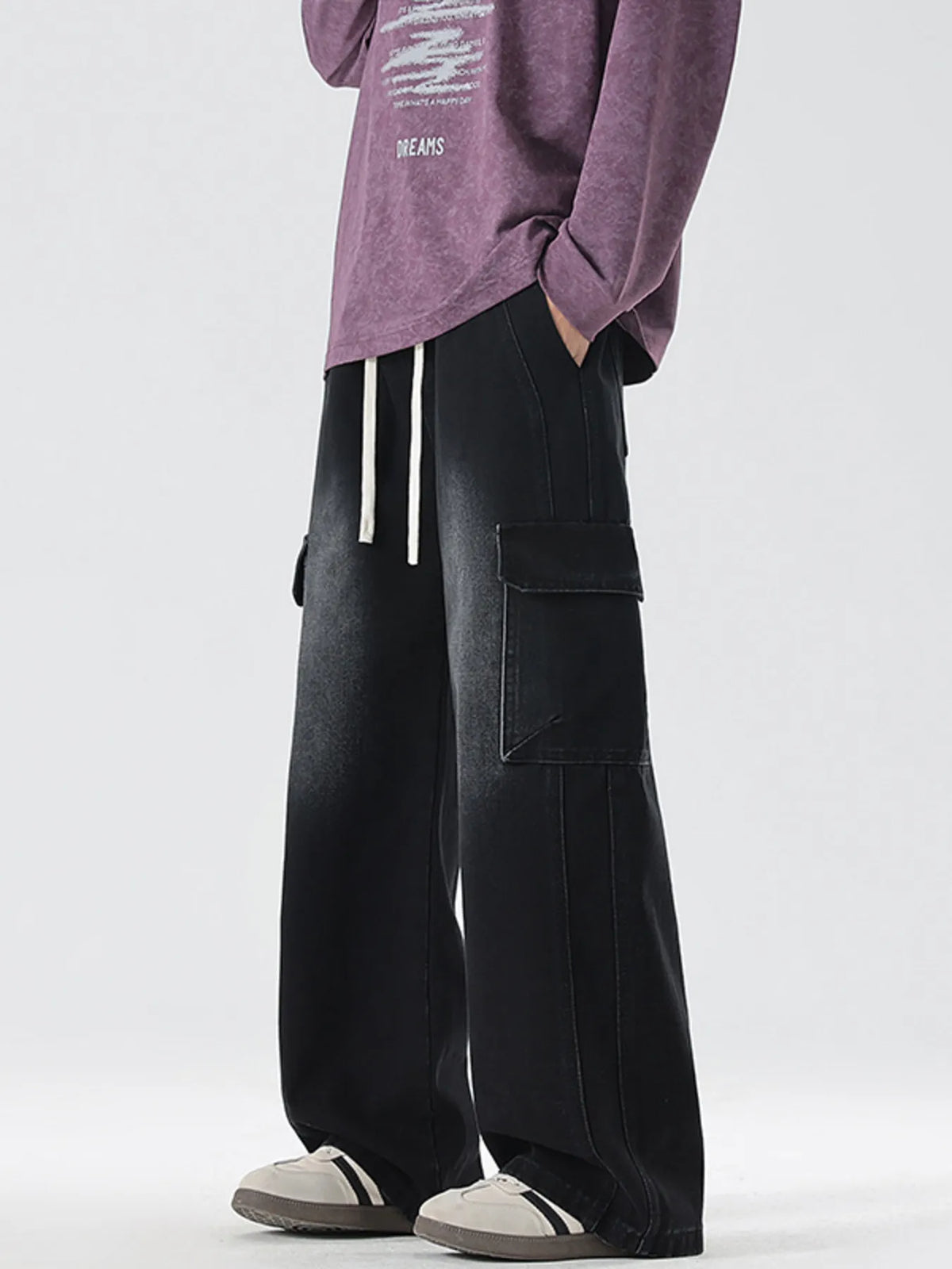 Washed black wide-leg cargo jeans with large cargo flap pockets and drawstring ties