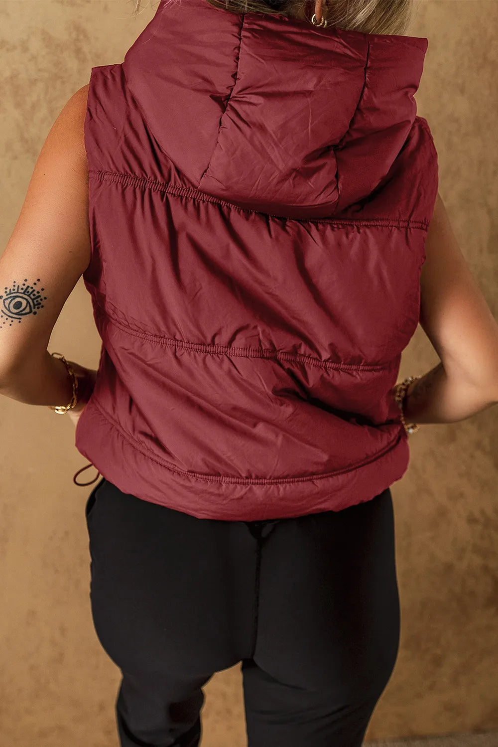 Burgundy hooded puffer vest coat, back view with quilted panels and drawstring hem