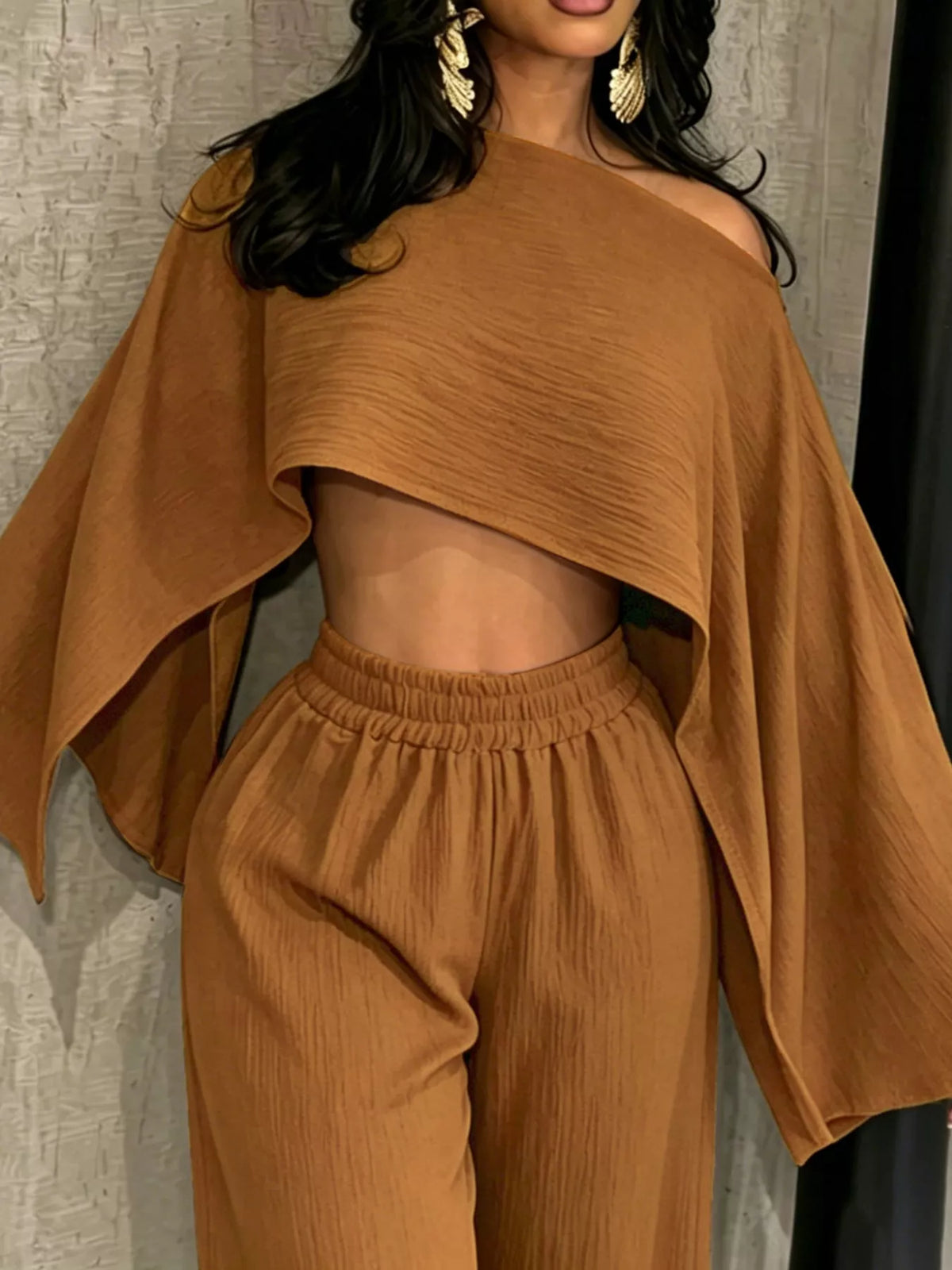Brown boat-neck crop top with draped sleeves and gathered wide-leg pants