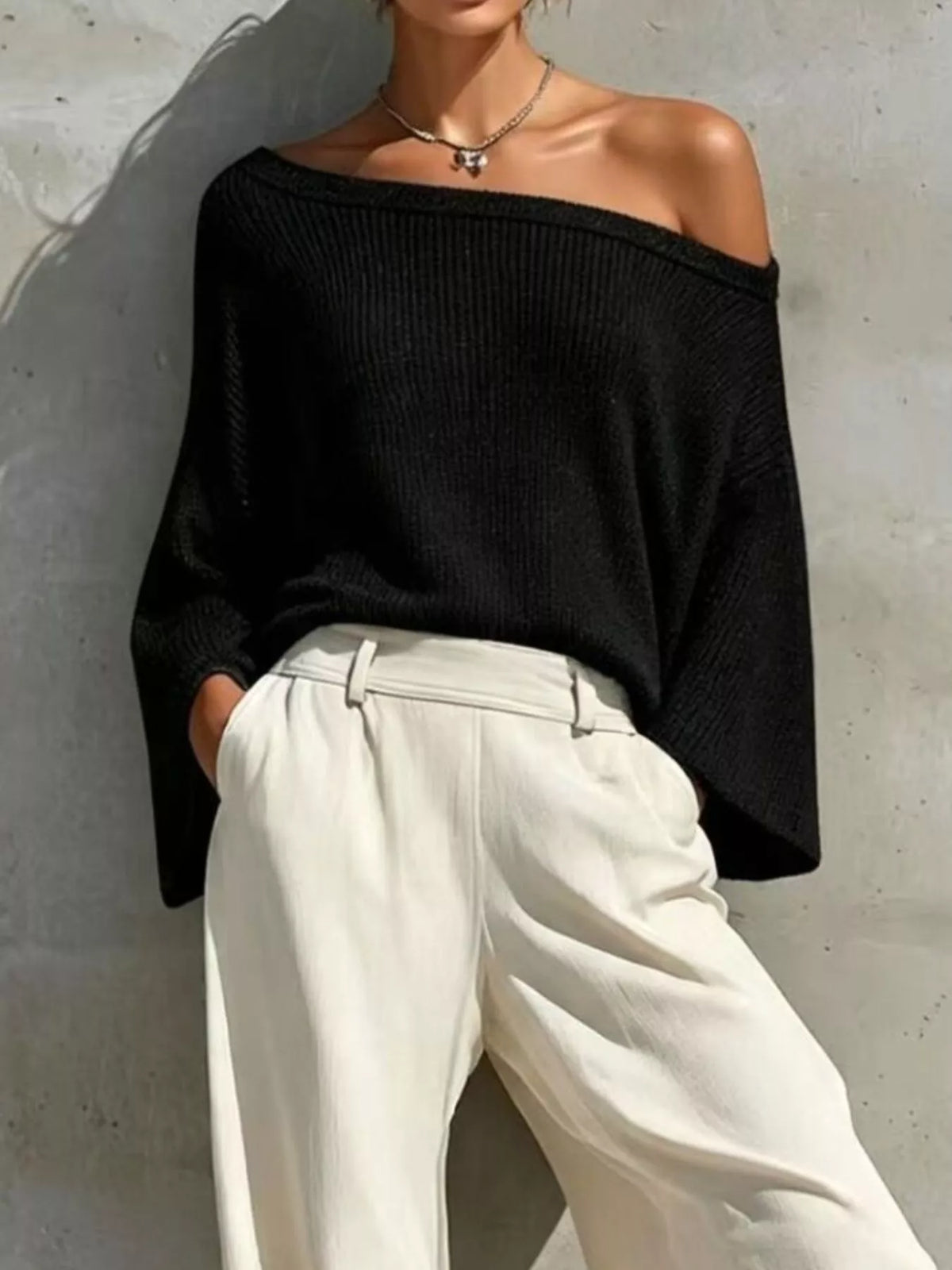 Black off-shoulder knit top with high-waisted white jogger pants and elastic cuffs