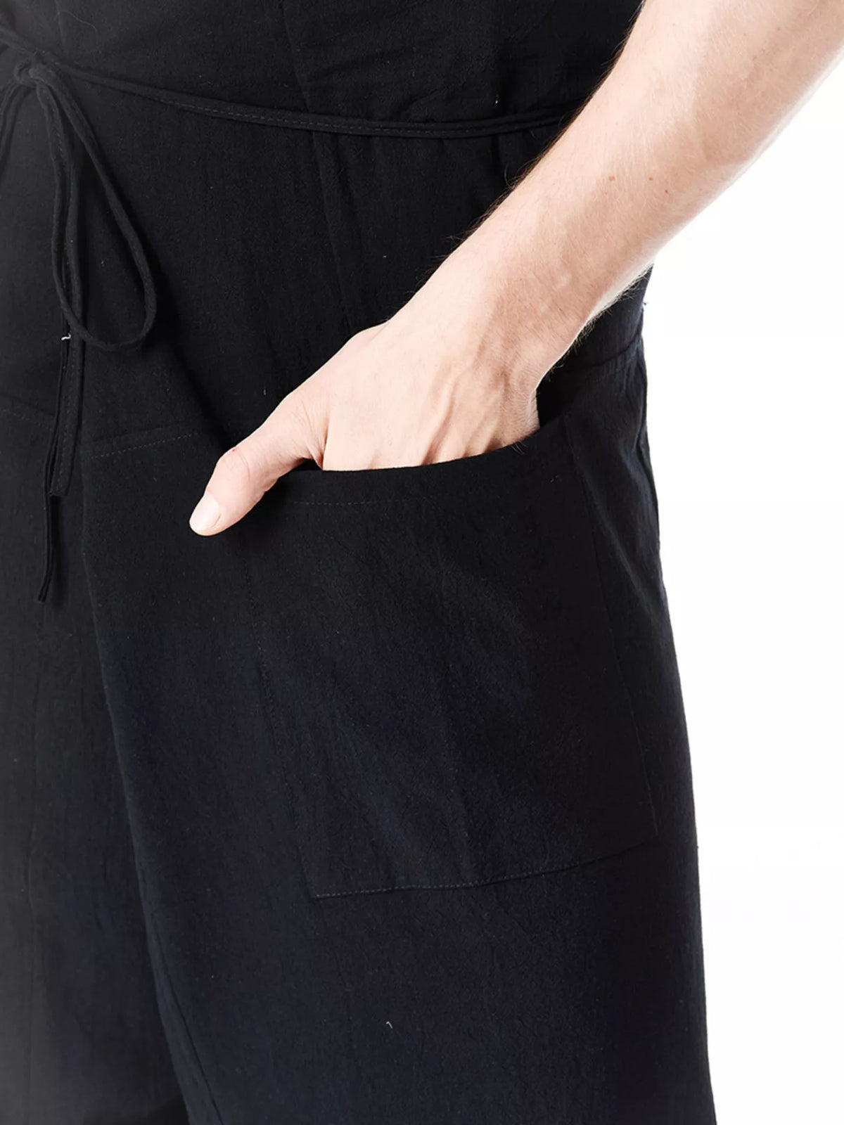 Black drawstring pants with front patch pocket and tie at waist