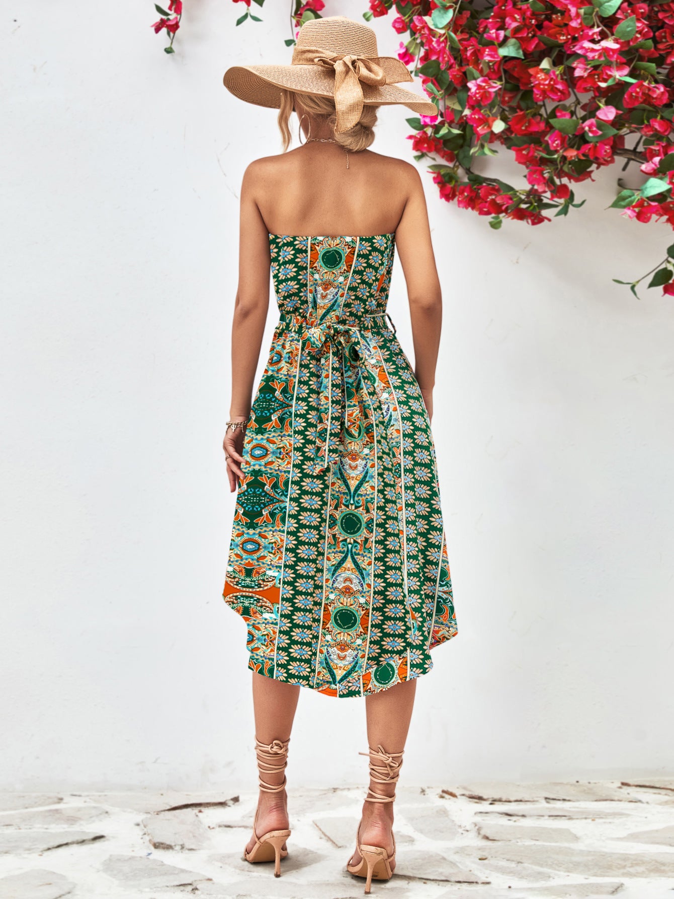 Back view of printed strapless tie belt dress in blue, multicolor medallion pattern, flared midi