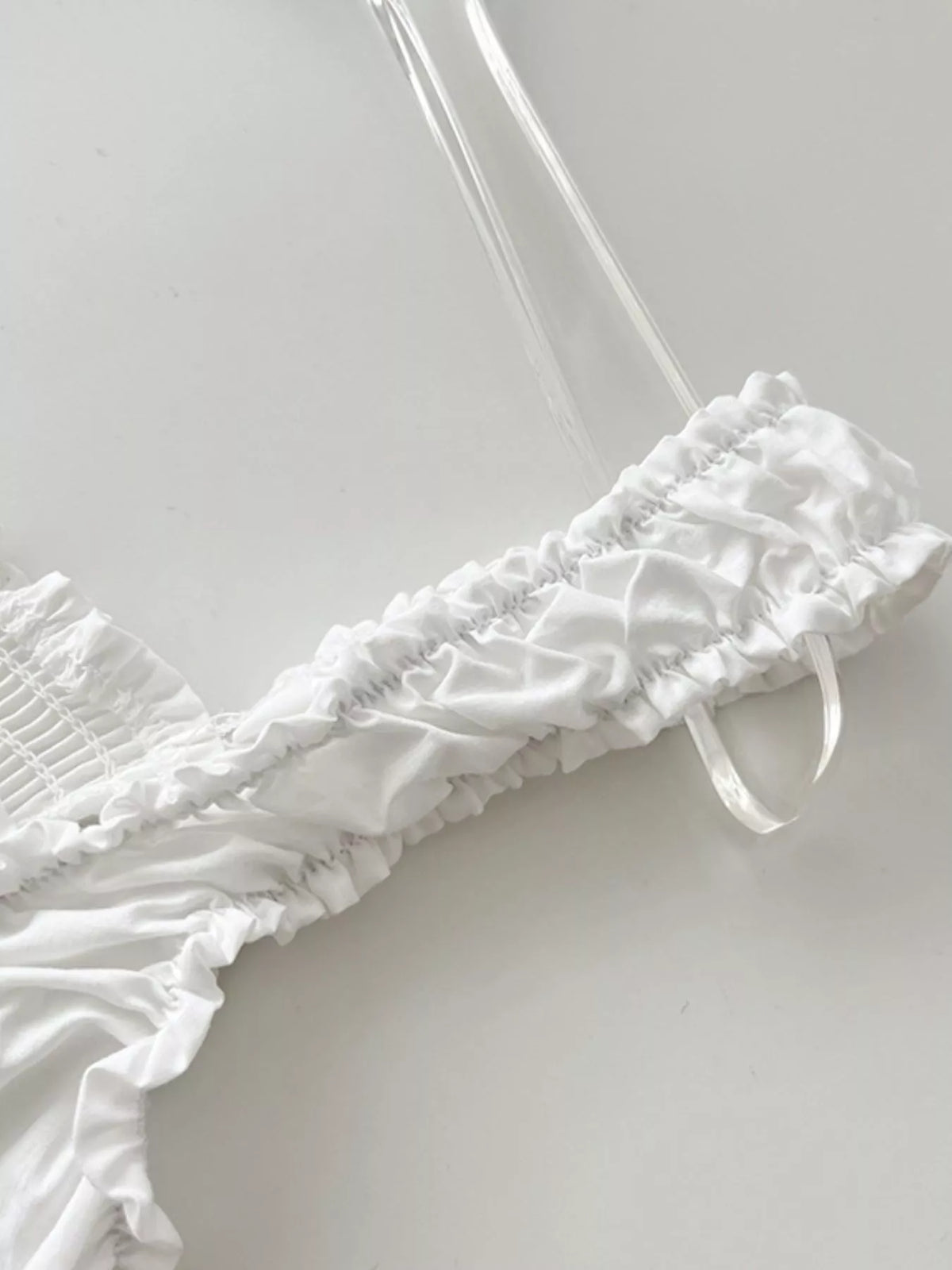 White ruffle-trim tie strap and shoulder detail on a square-neck dress
