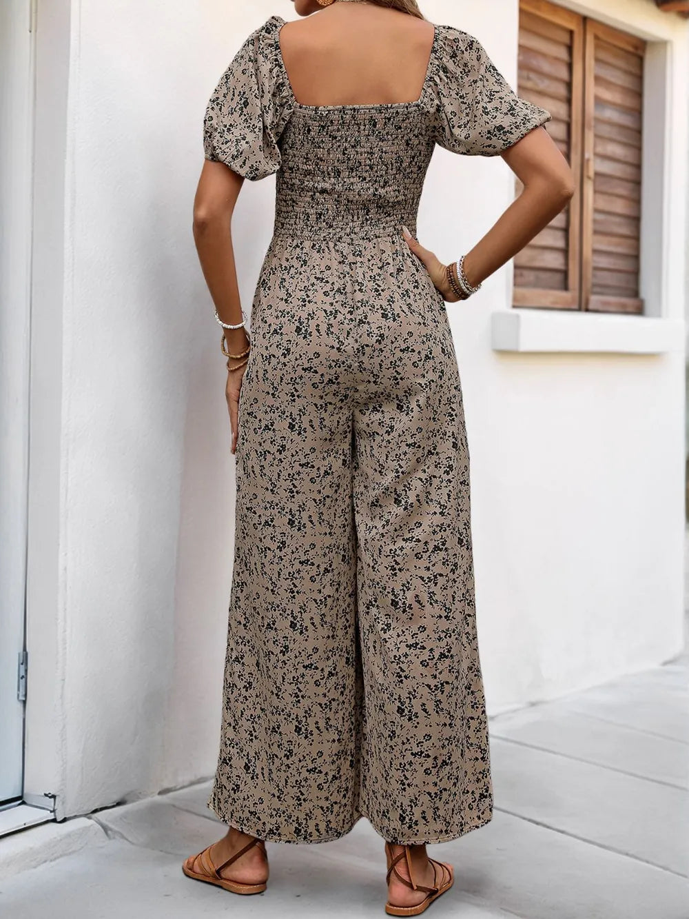 Back view of taupe printed jumpsuit with square neckline and puff sleeves