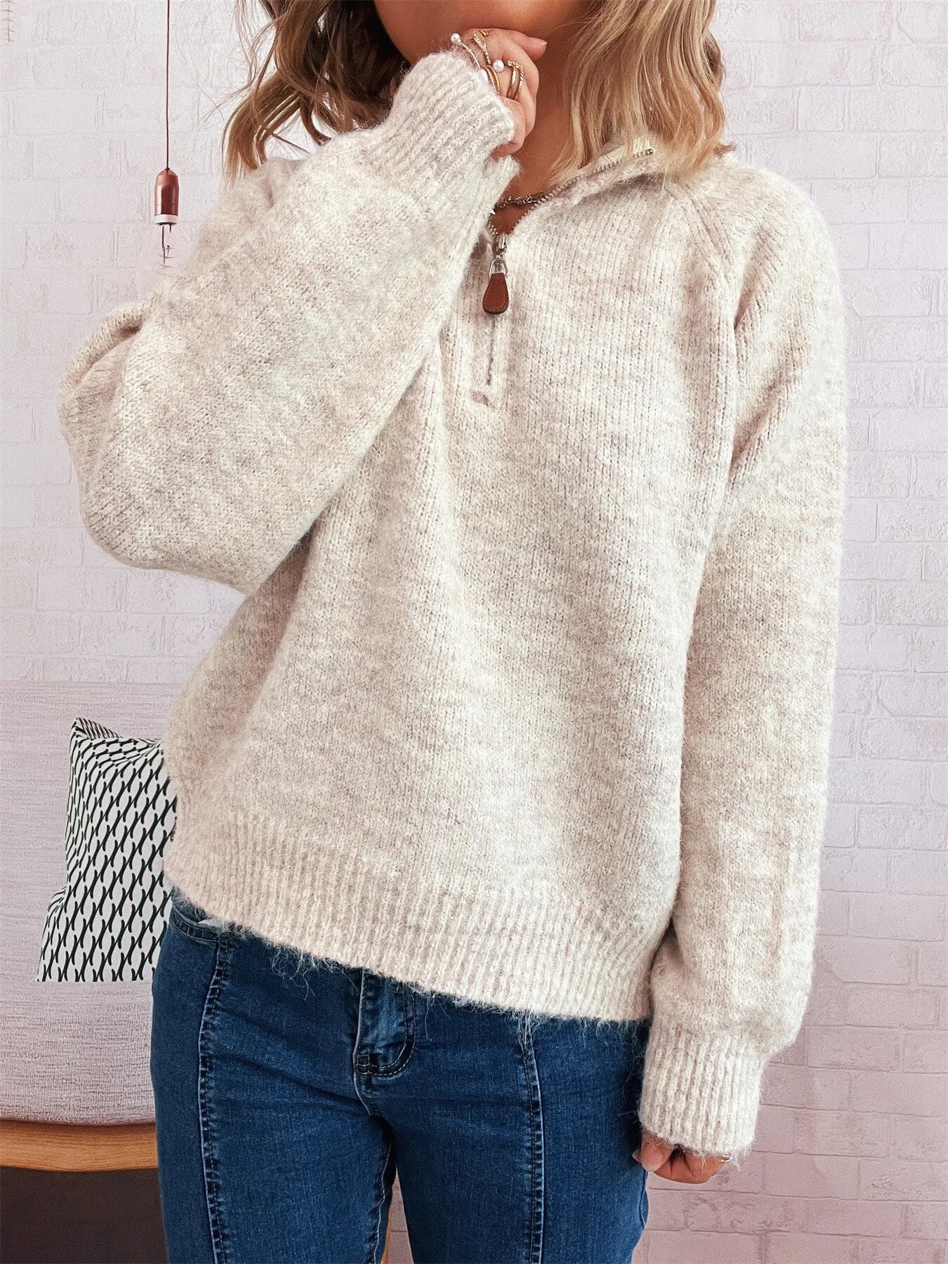Light beige quarter-zip sweater with ribbed cuffs and hemline