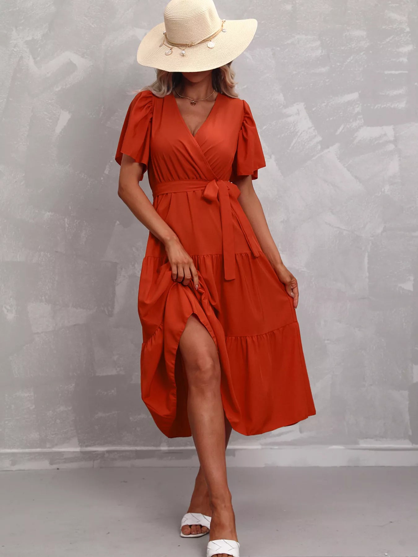 Orange-red tiered midi dress with V-neck, flutter sleeves, tie belt, side slit