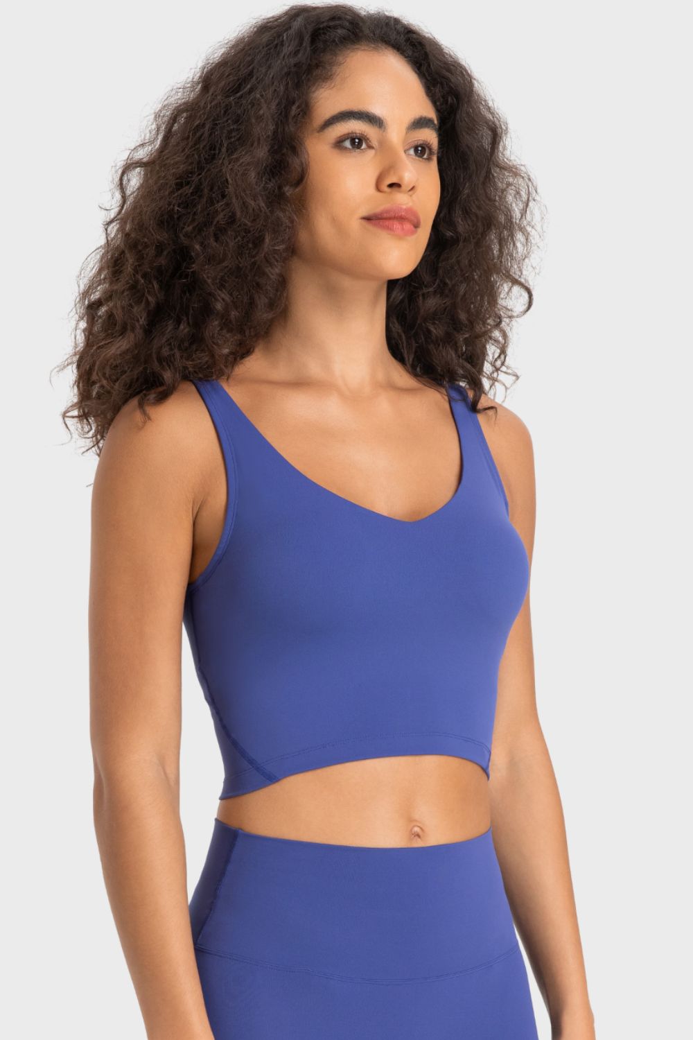 Deep V-neck crop sports bra, cobalt-blue color, front view with shoulder straps.