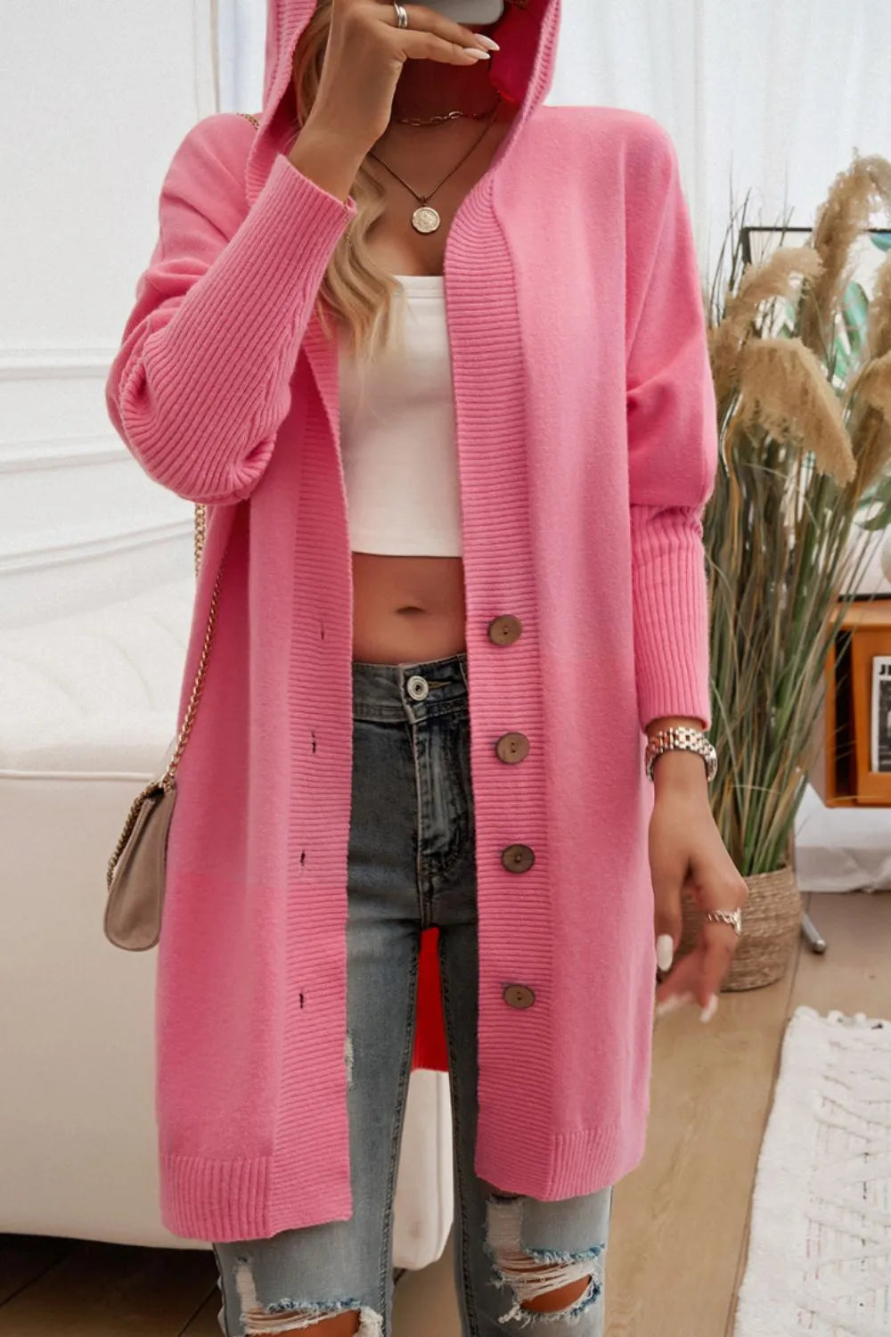 Pink hooded long-sleeve button cardigan with front buttons and knit texture.